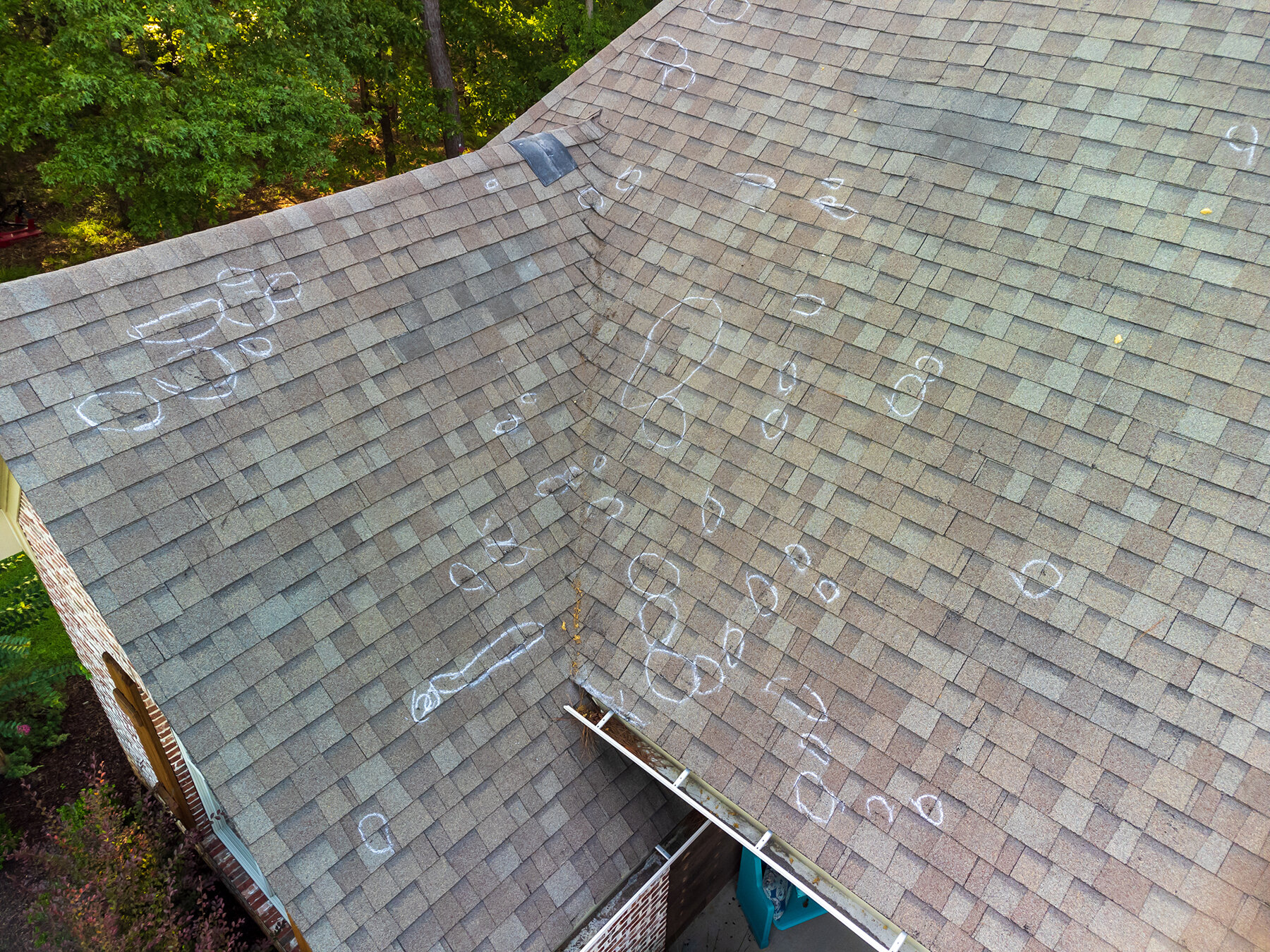 Close-up of hail damage on an asphalt shingle roof documented during inspection